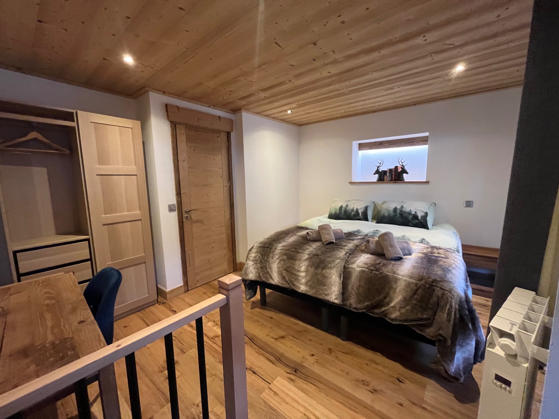 Prepared guest bedroom with wardrobe and desk in an alpine apartment